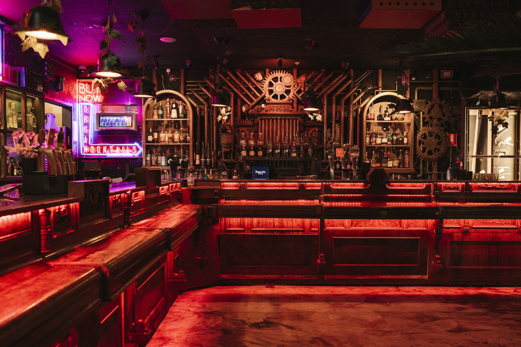 Pawn and Co's steampunk bar glowing in red and magenta light